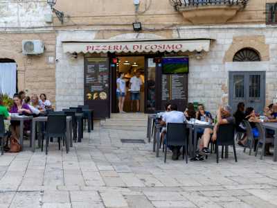 Per entrare nella pizzeria, il cui nome � impresso in rosso su una tenda da sole, bisogna salire tre gradini